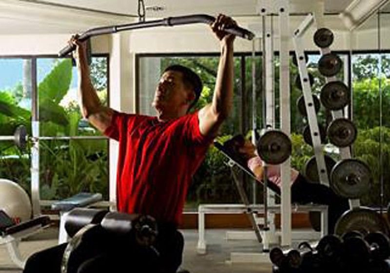 Dorsett Grand Subang Hotel Subang Jaya Einrichtungen foto A man using a lat pulldown machine